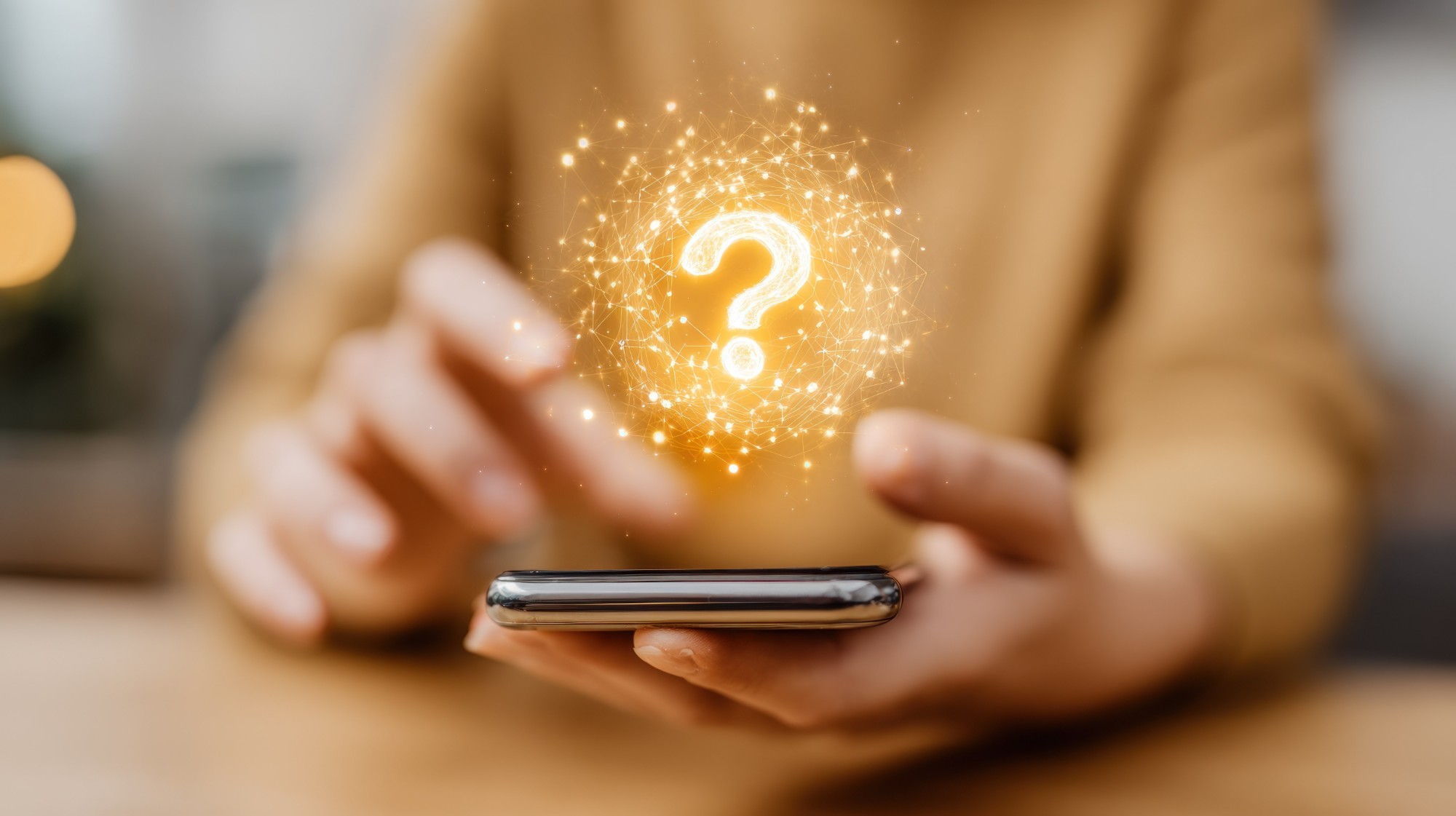 Person holding a phone with a glowing question mark